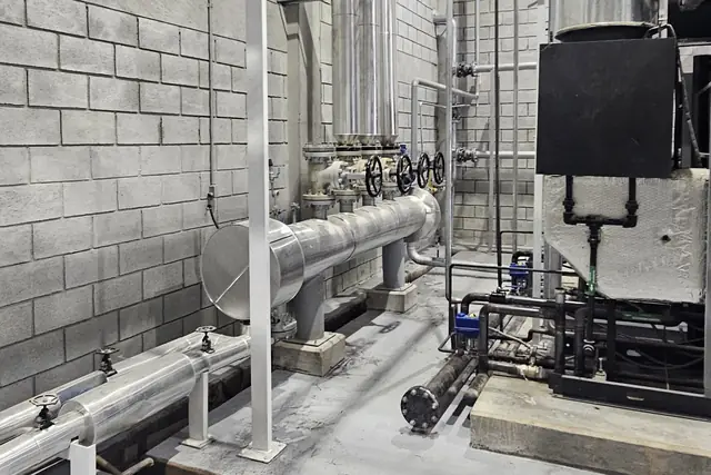 Tubulações isoladas e equipamento em sala técnica